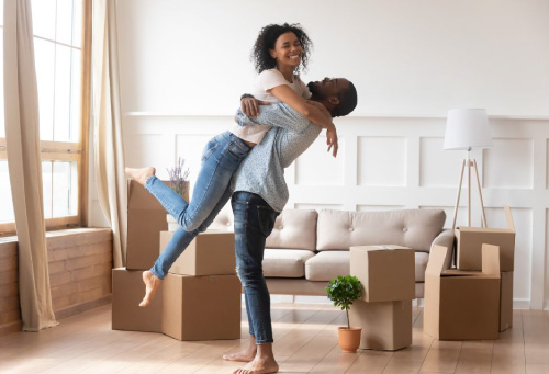 a couple looks happy in moving in day to their first home